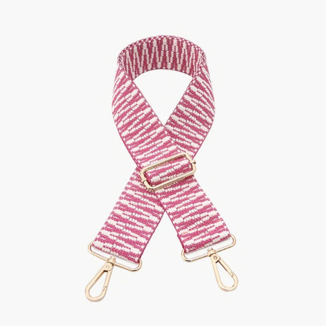 Pink and white striped bag strap with gold hardware on a light pink background