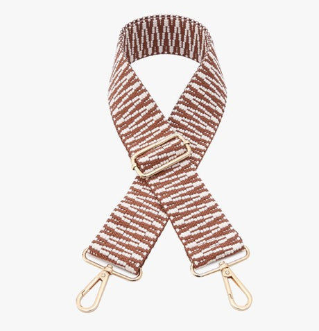 Striped bag strap with gold hardware on a white background