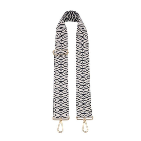 Black and white patterned bag strap with gold hardware on a white background
