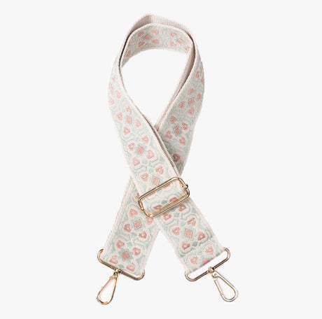 Patterned bag strap with gold hardware on a white background