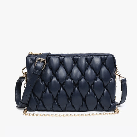 Navy quilted handbag with gold chain and strap on a light gray background