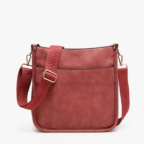A dusty rose red faux-leather crossbody bag with a matching patterned woven strap and gold-tone hardware, shown against a plain white background.