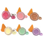Six mini ice cream-themed keychains arranged in two rows on a white background. Each keychain features a small waffle cone, an open round jar filled with colorful gel or glitter, and a small donut charm.
