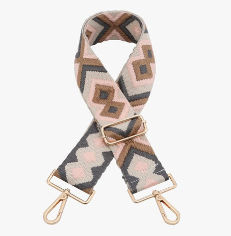 Patterned bag strap with gold hardware on a white background