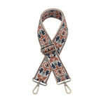 Floral patterned bag strap with metal hardware on a white background
