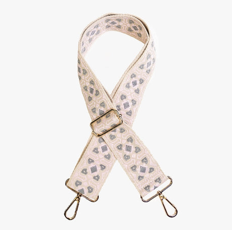 Patterned bag strap with gold hardware on a white background