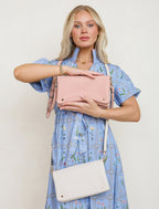 Woman holding a pink handbag with a beige background