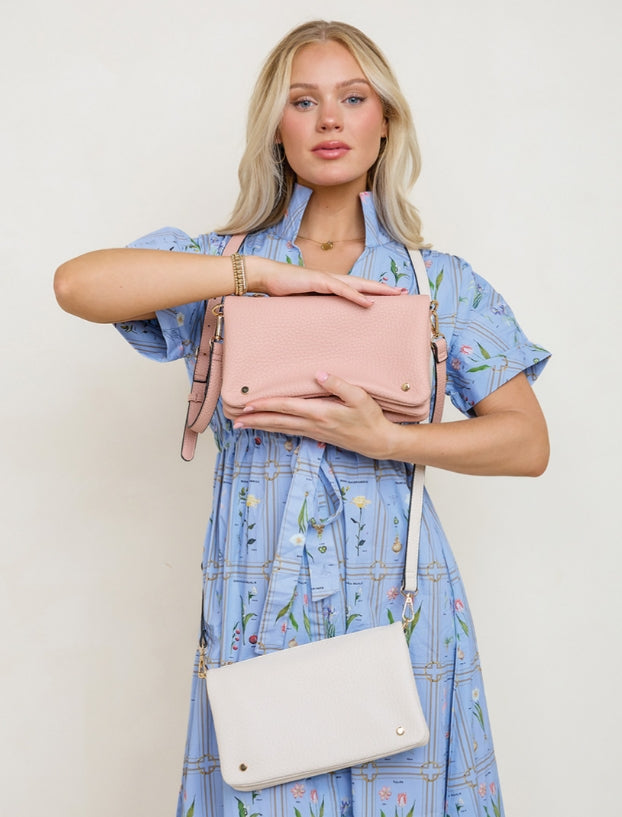 Woman holding a pink handbag with a beige background