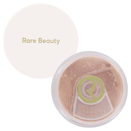 Rare Beauty loose setting powder in a clear circular compact with a white lid featuring the brand name, shown on a white background.