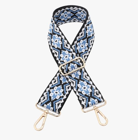 Patterned bag strap with gold hardware on a white background
